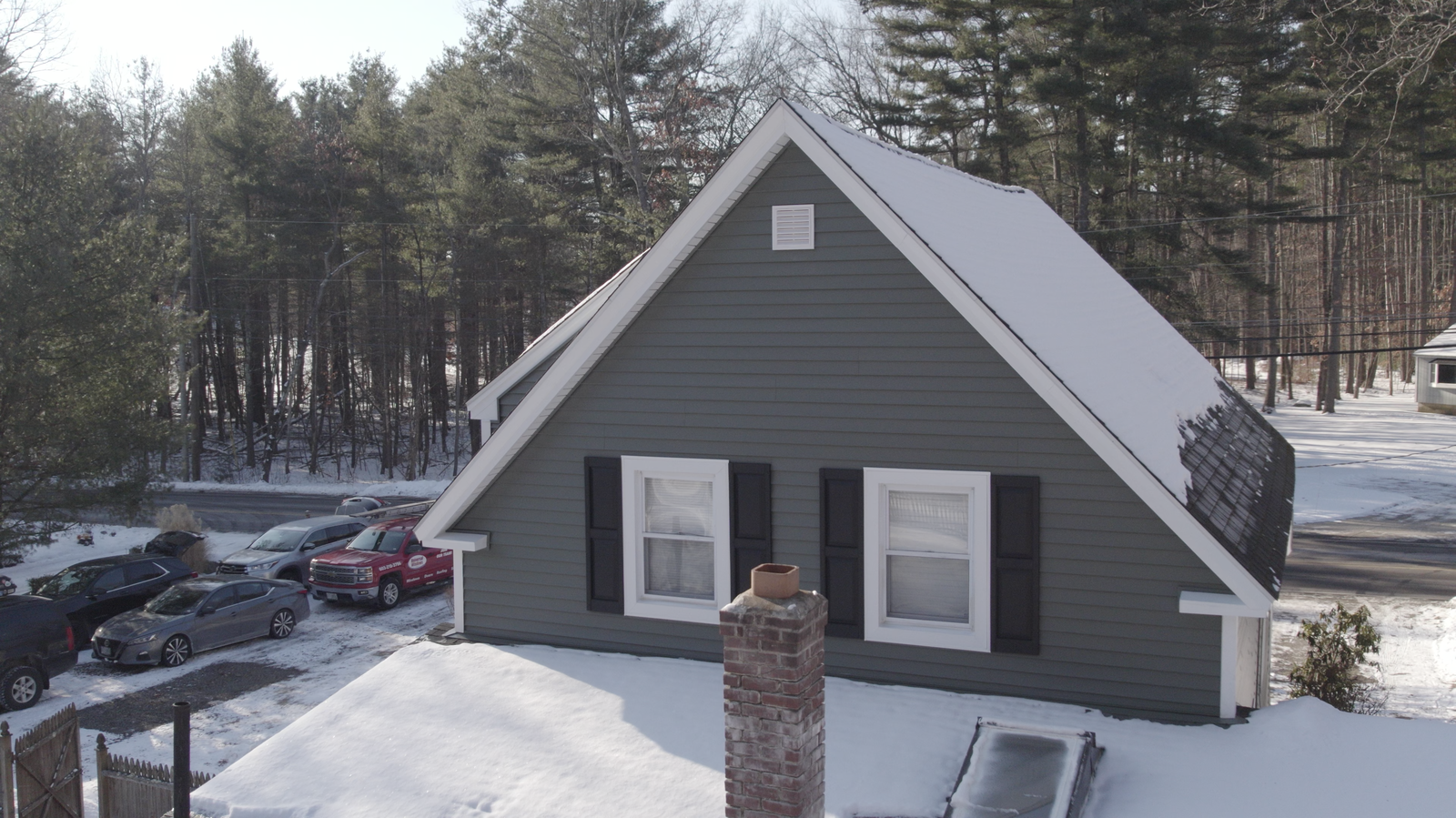 Aerial view of a service vehicle beside a winter property