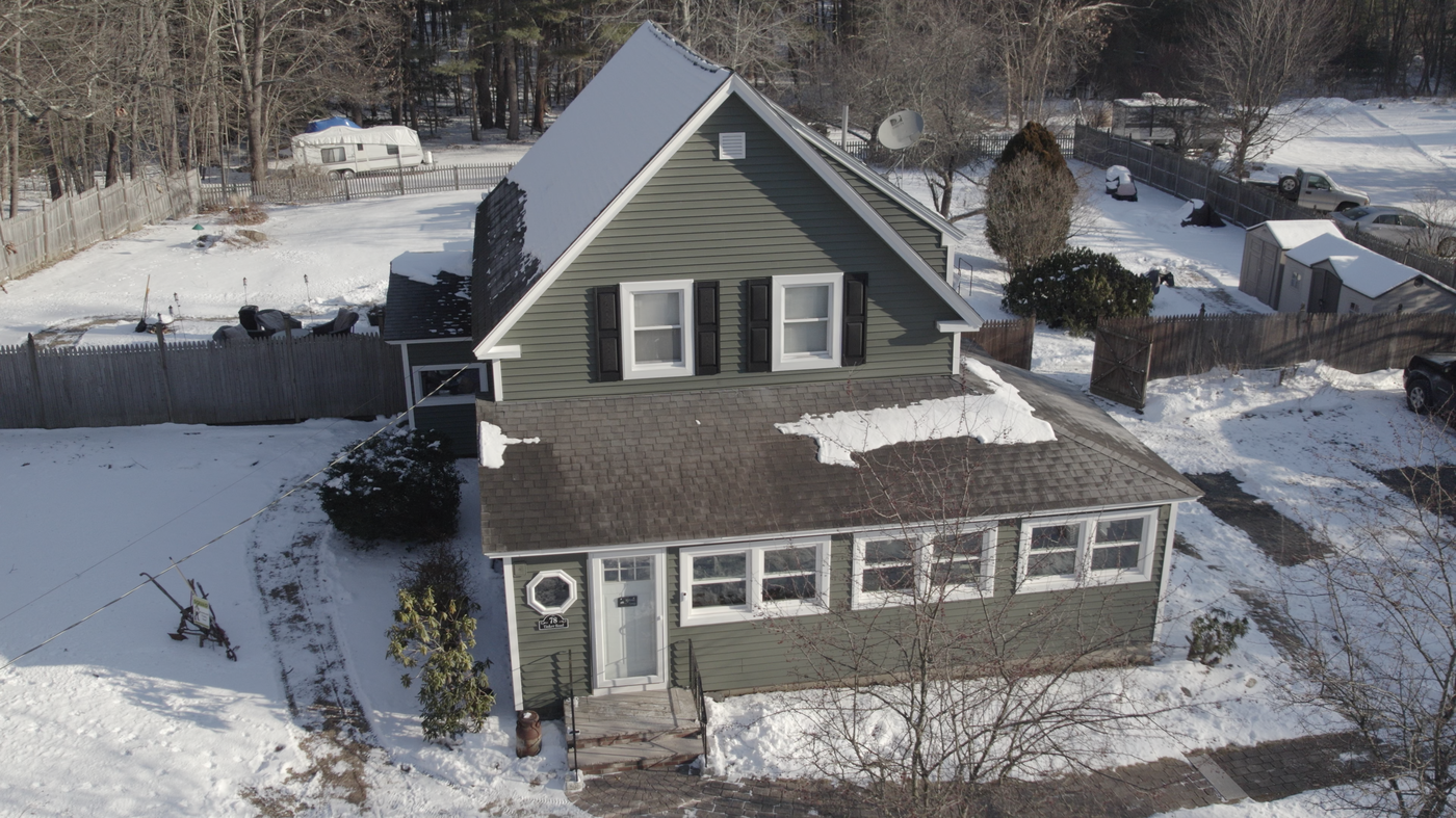 Aerial view of a snow-covered residential property