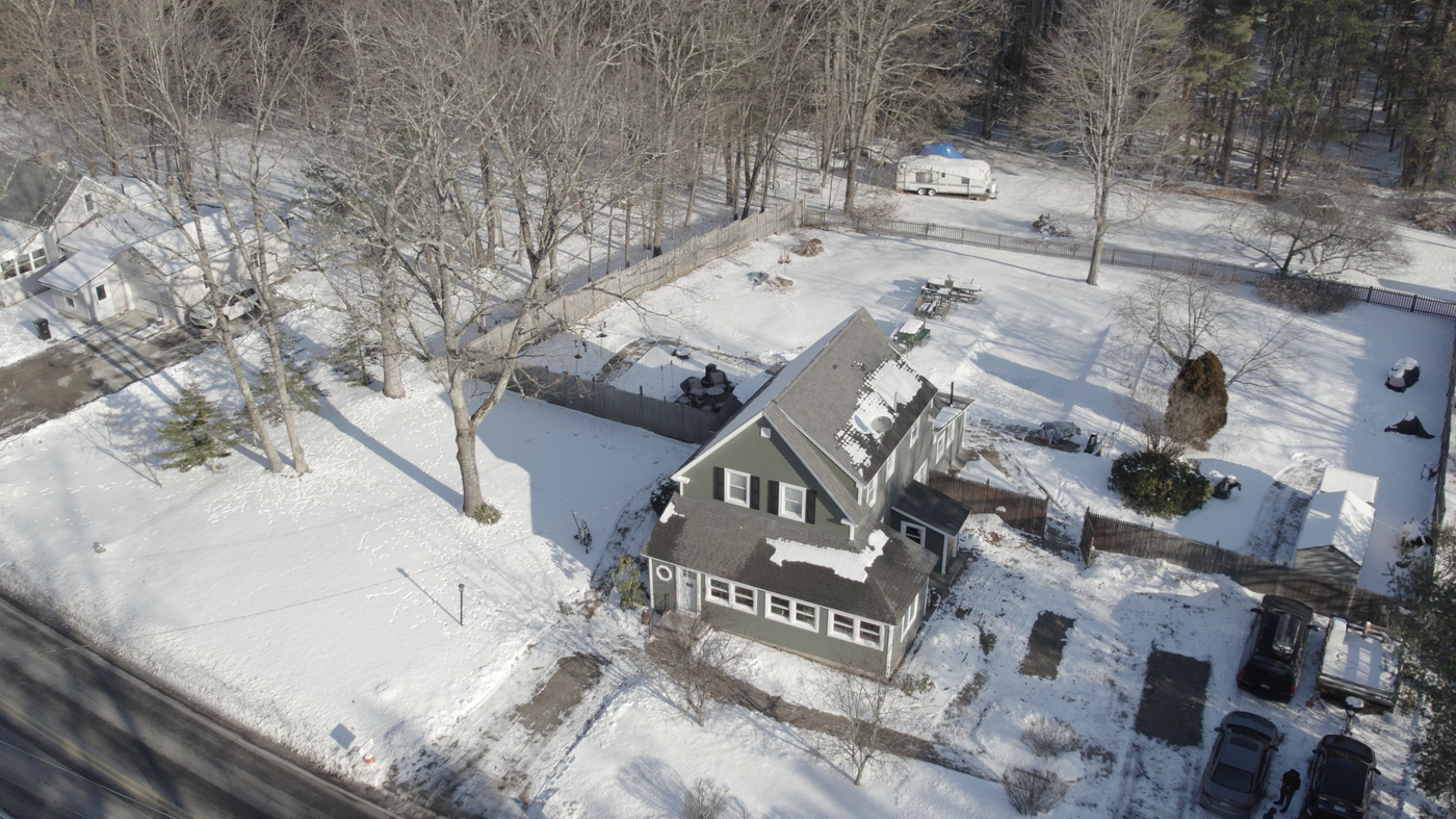 High aerial view of a snowy home and grounds