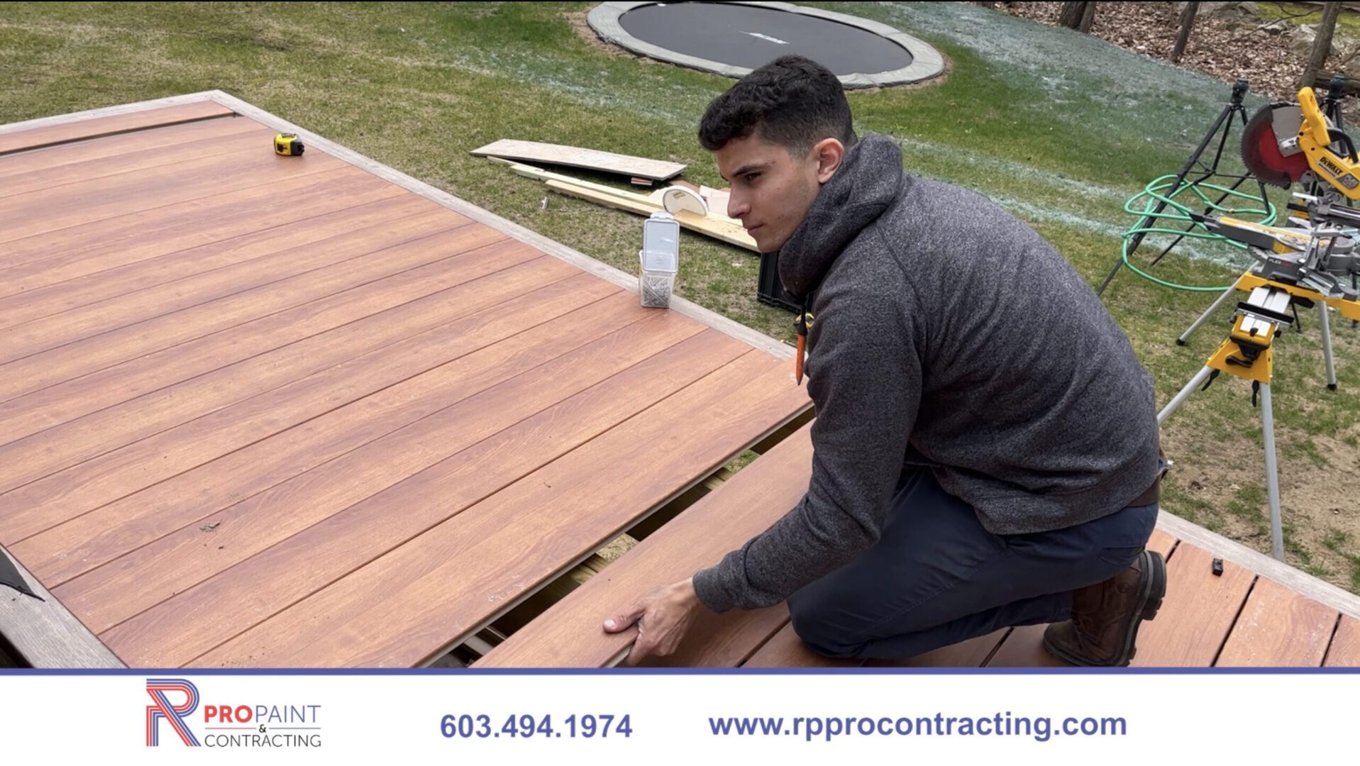 Worker installing composite deck boards outdoors