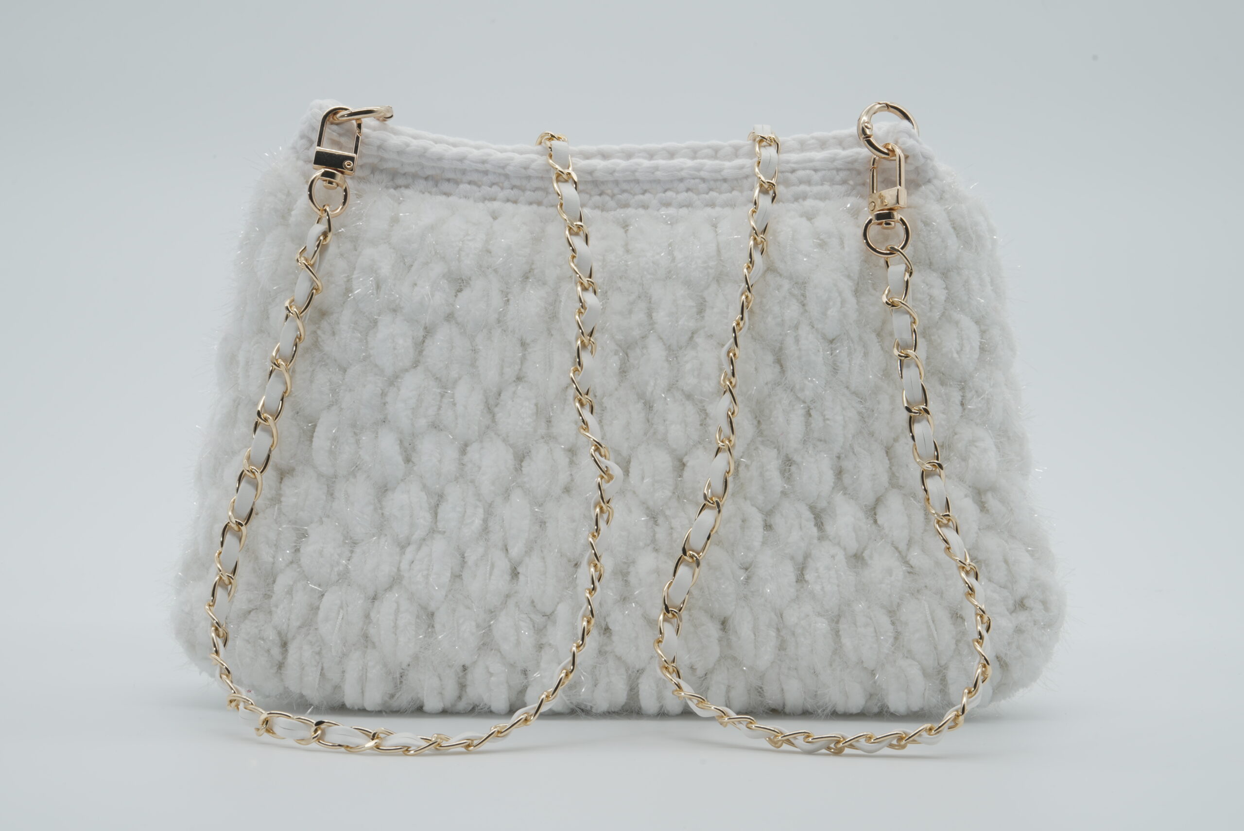 White textured handbag with gold chain strap.