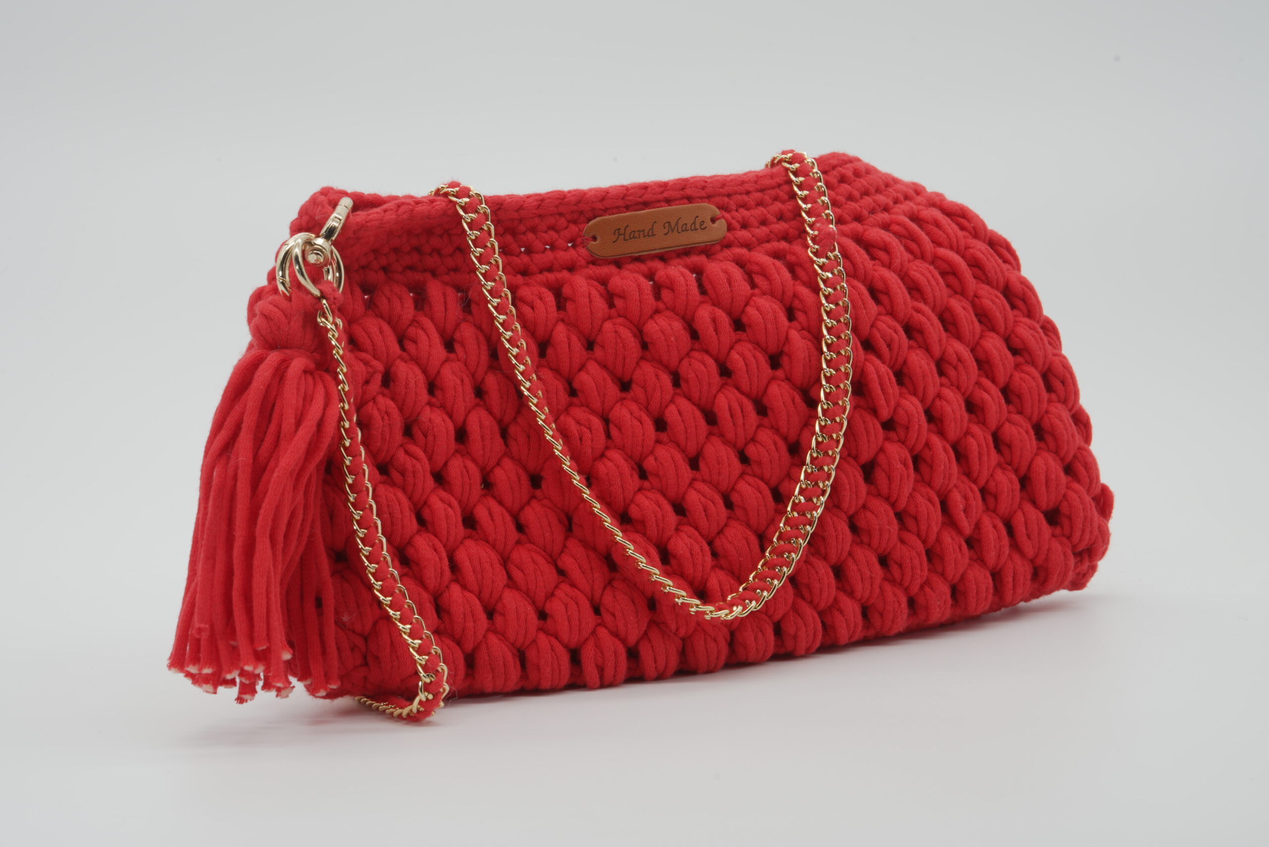 Red crochet handbag with gold chain strap.