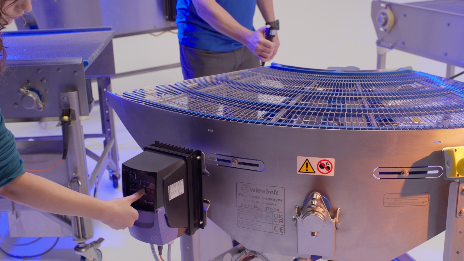 Hands at the controls of a curved conveyor — Wire Belt Company of America