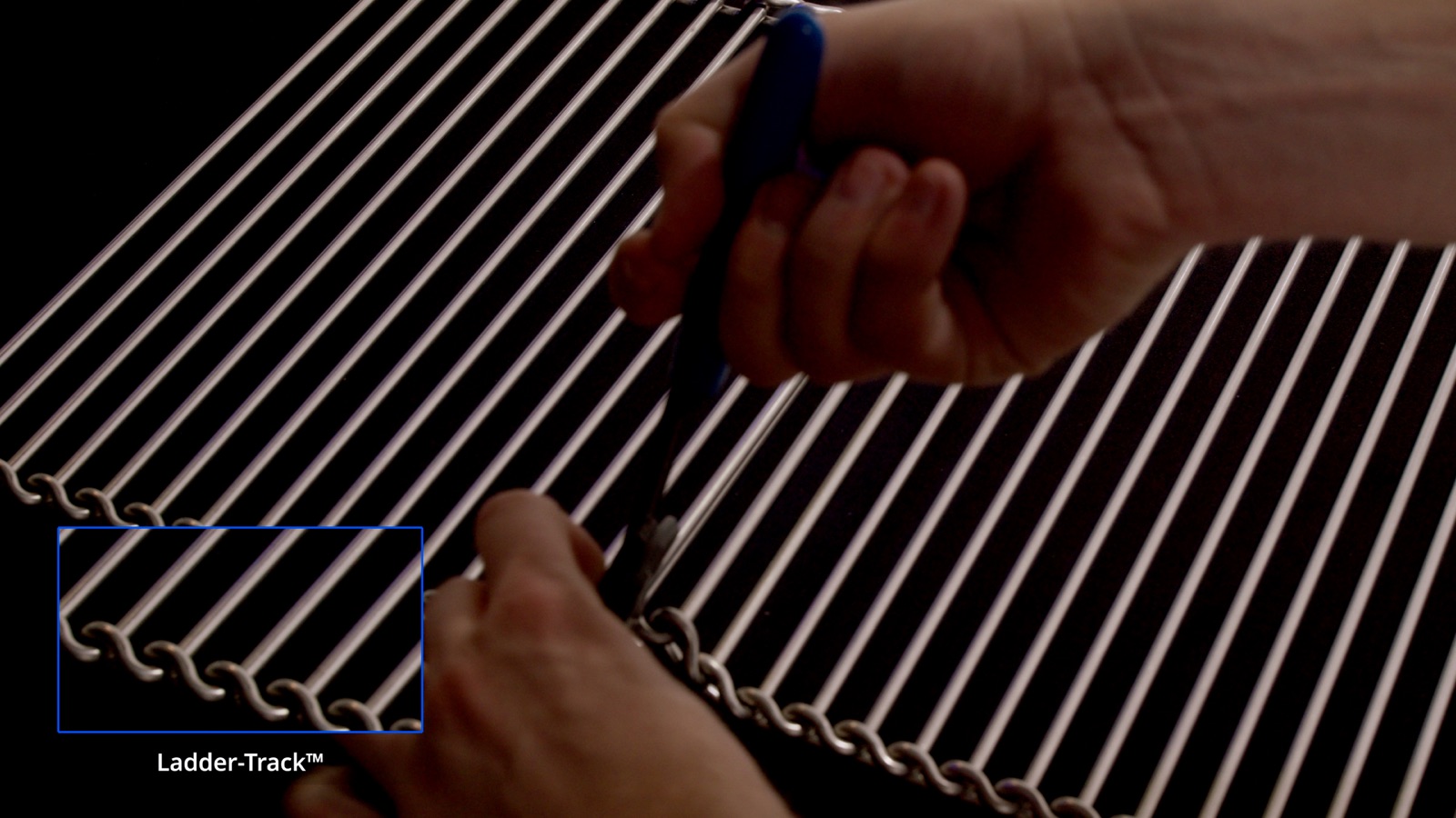 Close-up of hands working with wire belt rods — Wire Belt Company of America