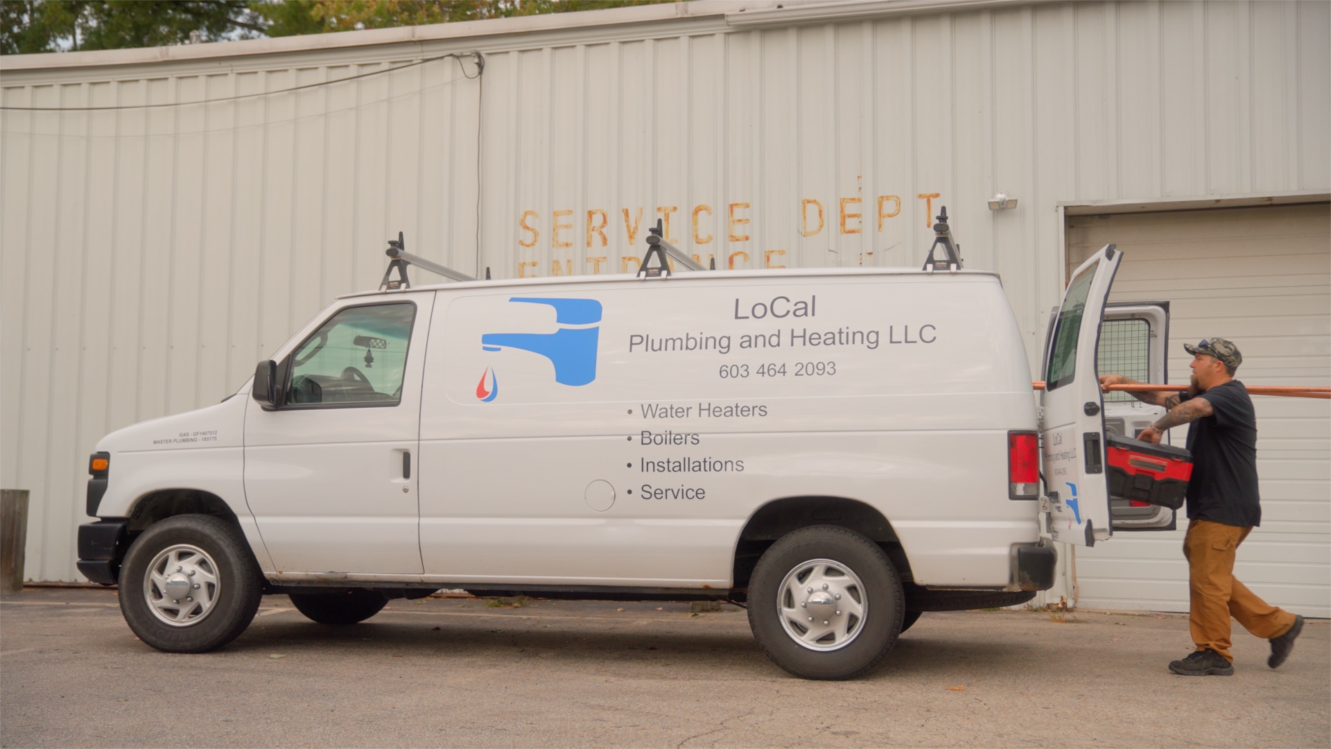 Plumbing van parked near a service department.