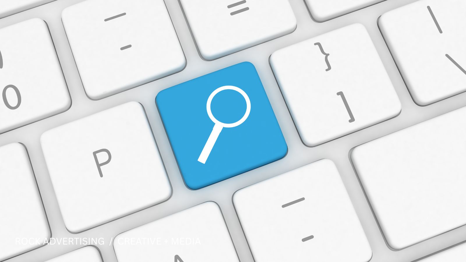 Blue search key with a magnifying glass on a white keyboard